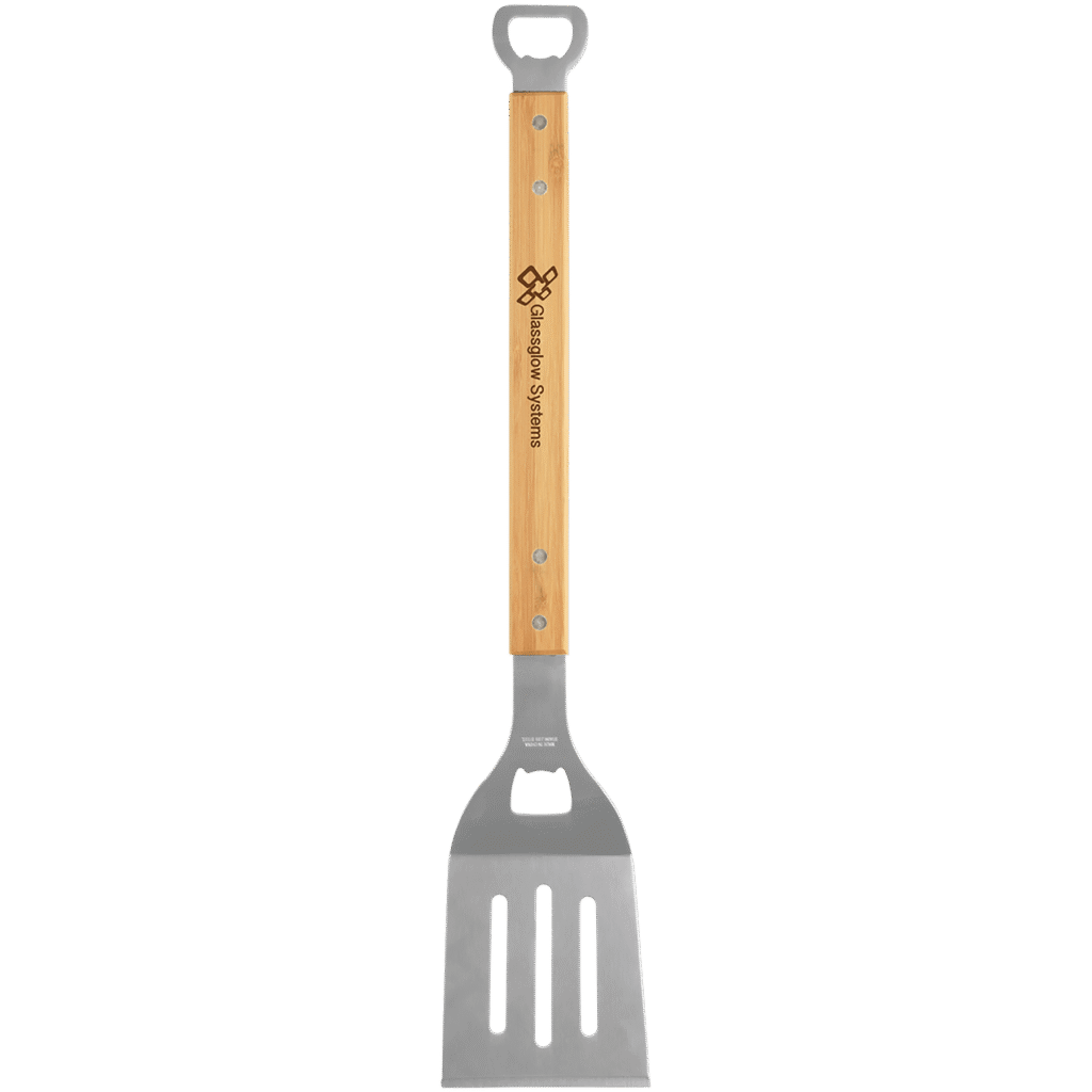 Stainless steel barbecue spatula with bamboo handle and engraved logo, featuring a built in bottle opener on a transparent background