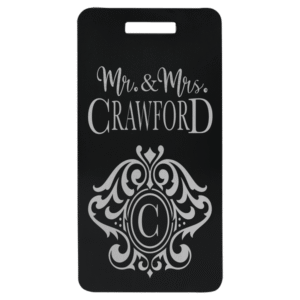 Black anodized aluminum luggage tag engraved with “Mr. & Mrs. Crawford” and decorative monogram.