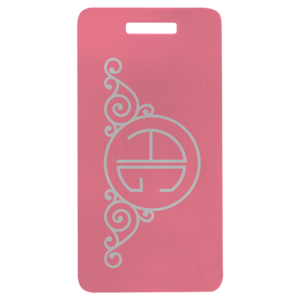 Pink anodized aluminum luggage tag with decorative swirl design and circular monogram.